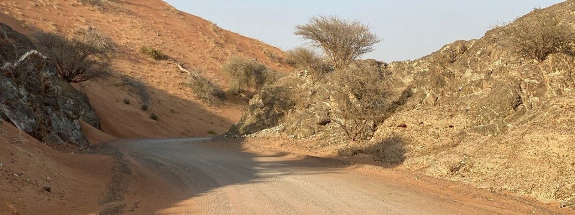 Dirt track between mountain and desert in Al Ghayl area