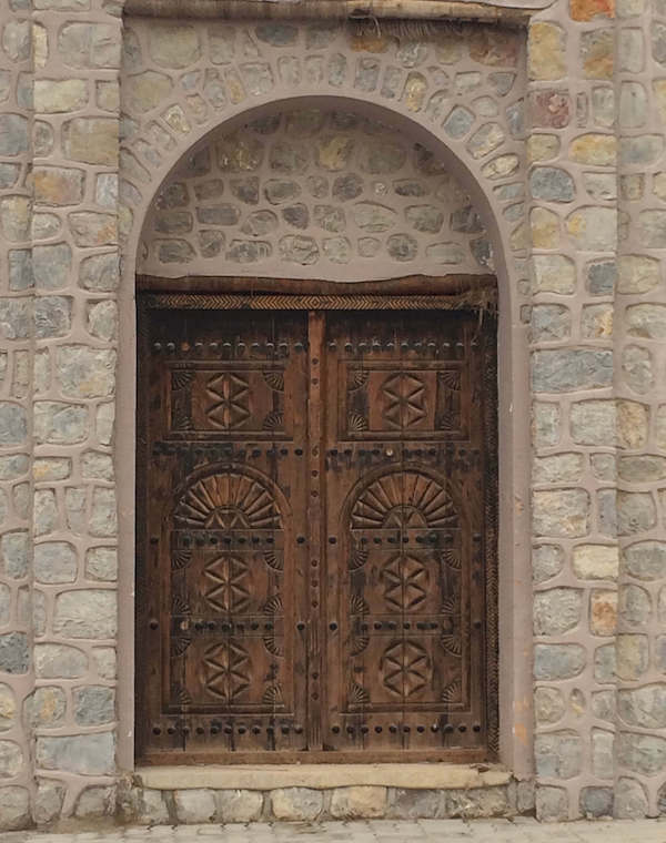 large wooden decorated door at Khatt, Ras al Khaimah