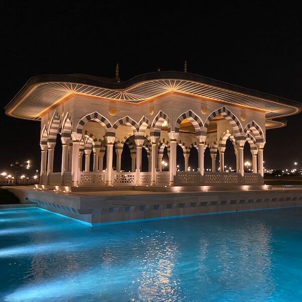 pavilion over blue water pool at sharjah grand mosque