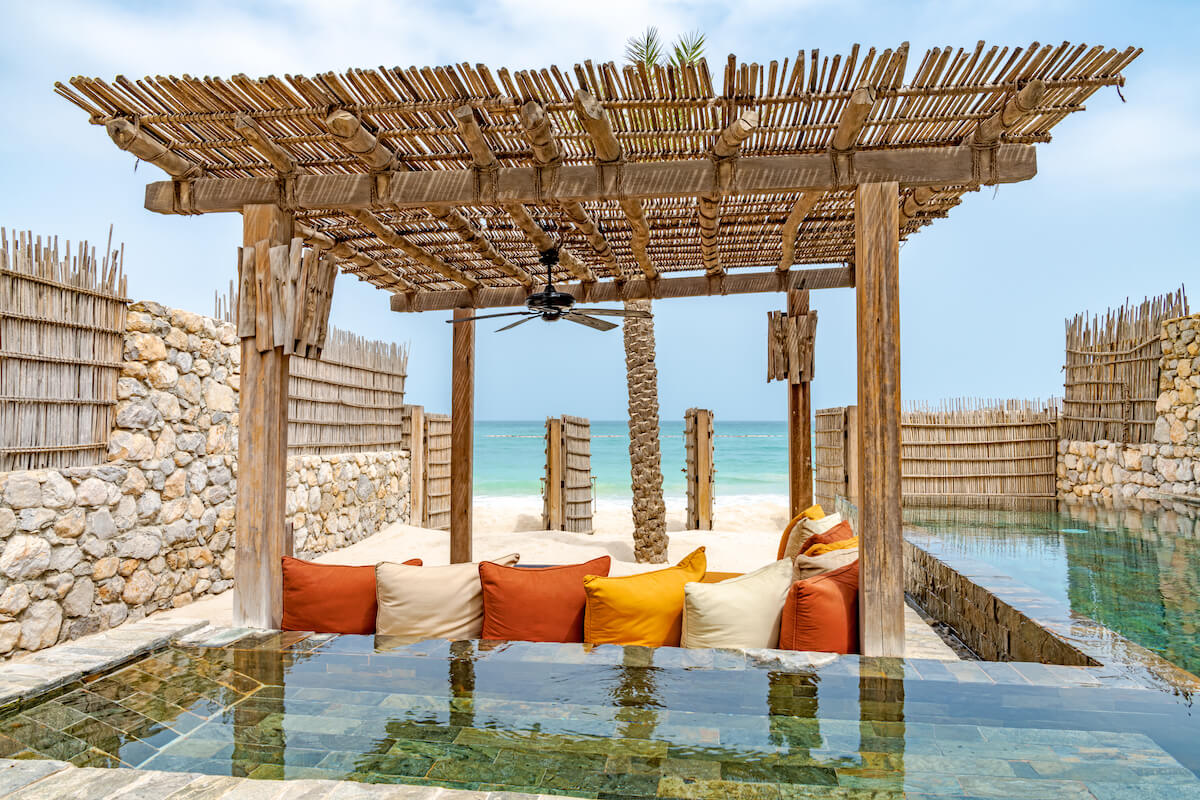 View of private pool, shade and seating across to beach and sea at zighy bay six senses Musandam