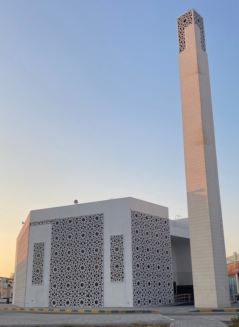 white mosque with simple, contemporary design and stand alone minaret
