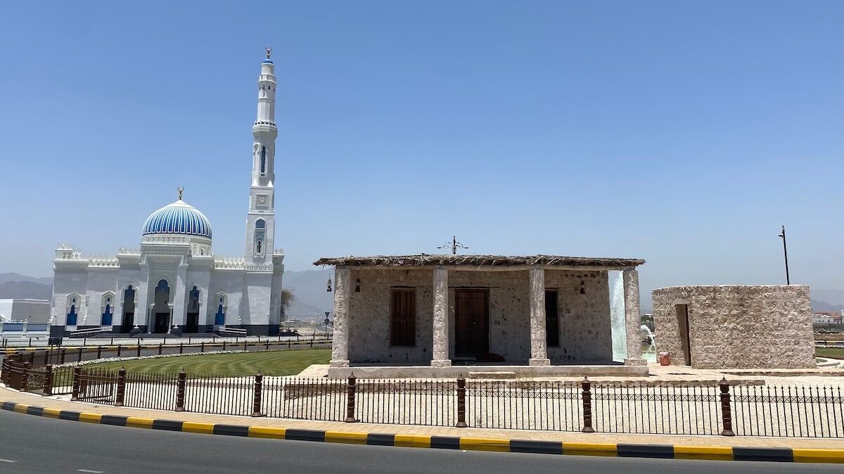 Heritage mosque on roundabout with decorative new mosque in background