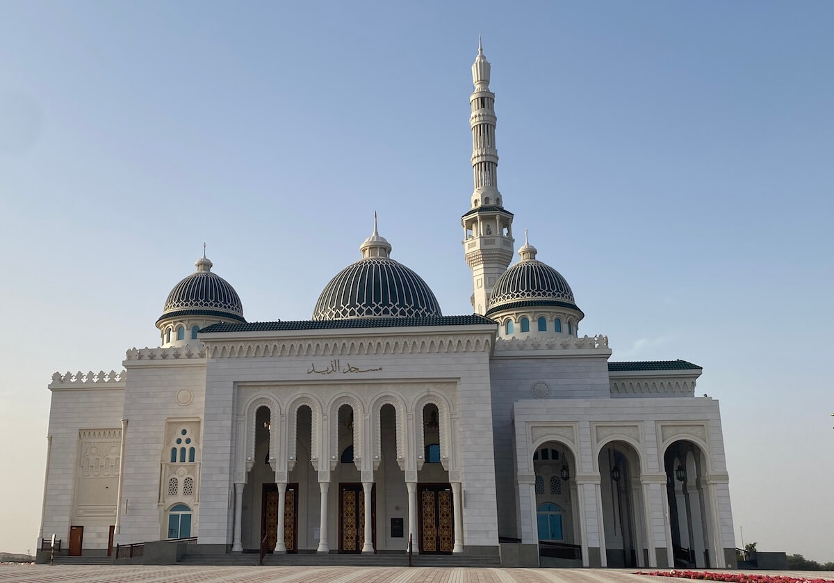 large mosque with dark green domes