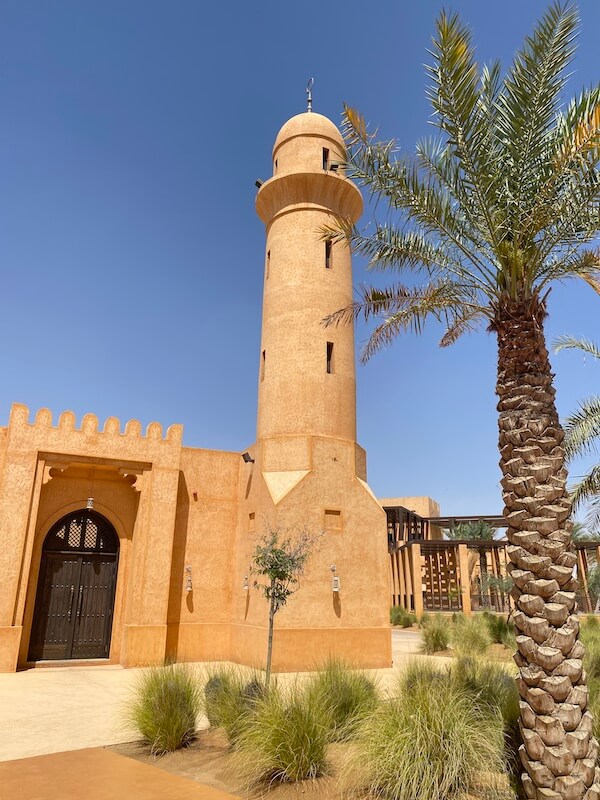 small mosque with wide minaret built with sand-coloured material