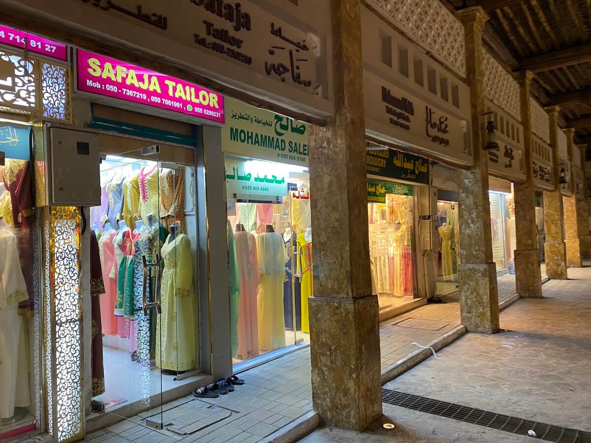 Traditional style souq with individual shops for tailoring. Colourful embroidered dresses are on display